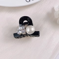 Detail of a mini black hair claw clip featuring a large pearl and rhinestone flower design - One Bead with Flower