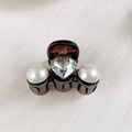Close-up of a mini hair claw clip featuring heart-shaped crystal and white pearls decoration - Two Hearts and Pearls