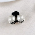 Detail shot of mini pearl and rhinestone hair claw clip on soft beige satin background - Two Rhinestones and Bead