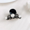 Close-up of a mini black claw clip with elegant pearls and sparkling rhinestones - Three Rhinestones and Beads