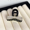Dettaglio macro di un fermaglio per capelli a fiocco nero con bordi dorati e strass lucidi - Fiocco Base Nera Strass Bianco