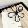 Pasador de flores gris con diamantes de imitación y perla negra en tarjeta blanca - Flor