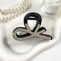 Dettaglio della clip per capelli nera con strass scintillanti su vassoio bianco - Nero Con Strass Bianchi
