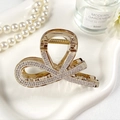 Dettaglio del fermaglio per capelli in acrilico ambra con strass lucidi e molla dorata - Grigio Trasparente con Strass Bianchi