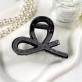 Dettaglio macro della molletta per capelli nera con strass su vassoio in ceramica - Nero con Strass Neri