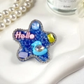 Gros plan détaillé d'une pince à cheveux étoile bleue avec texte Hello et strass brillants - Bleu Étoilé