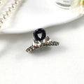 Detail of elegant black hair claw clip with champagne crystal bow on white tray - No.1 Black