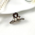 Detailed macro view of a mini bow-shaped hair claw clip with dark grey crystal rhinestones - Style 1 Brown
