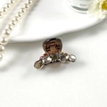 Close-up of a mini French style hair claw with grey crystals and translucent resin - 8332 Brown Clip