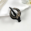 Detailopname van een vintage vlinderhaarspeld met champagne steentjes en zwarte basis - Vlinder Stijl