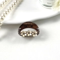 Dettaglio della pinza per capelli in resina marrone con motivi floreali bianchi e strass - Semicerchio (6108657919432)