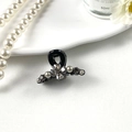 Close-up of black hair clip featuring sparkling rhinestones and pearl flower arrangement - Four Leaf Black Base Gray Rhinestone