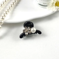 Detail of mini black hair claw clip featuring sparkling rhinestones and a white pearl accent - Plum Blossom Black White Pearl
