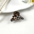 Detail showing an amber hair claw clip with large brown pearl and sparkling grey rhinestones - Butterfly Pearl Brown