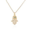 Nahaufnahme der goldenen Hamsa-Halskette mit Zirkon-Steinen und grünem Evil Eye - Hamsa Hand mit grünem Auge (25632)