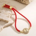 Macro detail of red woven cord bracelet with gold Virgin Mary medal and pavé zircon stones - Round Medallion Style (32477)