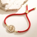 Detail of red braided rope bracelet with 18K gold Virgin Mary pendant and zircons - Classic Round Frame Style (32482)