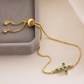 Detail of adjustable 18K gold cross bracelet with green zircons on velvet box - Green And White Cross (32064)