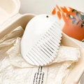 Detailed macro view of an oval white marble patterned wide-tooth comb with gold hanger - Off-White Marble Pattern
