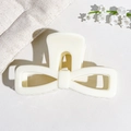 Dettaglio del fermaglio per capelli a fiocco bianco crema con finitura UV lucida su pelle - 9.5cm Bianco Crema Solido