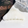 Detailweergave van de driehoekige haarklem met marmertextuur op wit lederen achtergrond - Beige