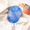 Vue détaillée du peigne en résine à motif marbré bleu et blanc avec trou de suspension - Marbre Bleu Violet Clair