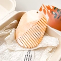 Détail d'un peigne effet marbre pêche avec trou métallique et coffret cadeau raffiné - Orange Clair Marbré