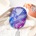 Détail d'un peigne ovale en acétate avec motif marbré bleu et violet à larges dents - Marbre Bleu Violet Foncé