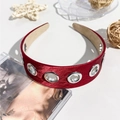 Détail du serre-tête en satin rouge avec œillets métalliques et doublure antidérapante - Bordeaux
