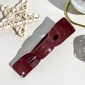 Dettaglio ravvicinato di un fermaglio per capelli a fiocco bordeaux con finitura lucida - Rosso Vino Lucido