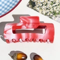 Dettaglio della grande pinza per capelli con trama marmorizzata su sfondo decorativo - Clip Quadrata Curva 10.5cm / Rosso (89133)