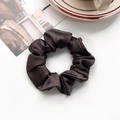 Detailed macro view of the dark brown silk scrunchie with pleated texture on white leather - Silk Pleated Large Scrunchie - Dark Brown