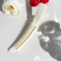 Detailansicht einer weißen Styling-Haarklammer mit integrierten Kammzinken auf Texturhintergrund - 14cm Gitter Haarclip - Off-White