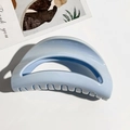 Nahaufnahme einer hellblauen halbkreisförmigen Haarklammer mit glänzendem Finish - Mond Design / Himmelblau