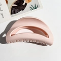 Draufsicht auf eine rosa hohle Haarklammer mit glänzender Oberfläche auf weißem Grund - Mond Design / Hellrosa