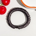 Close-up of a pleated black silk scrunchie with a sleek black bead detail for ponytails - Silk Pleated Hair Band - Dark Purple