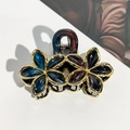 Detailed macro view of the golden metal alloy frame and gradient resin flower hair claw - 9cm Gold Edge Double Flower - Red Blue