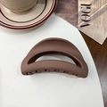 Brown matte shark hair clip in half-moon design displayed on a stylish desk setting - Moon Clip / Silicone / Matte Coffee