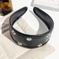 Détail d'un serre-tête en cuir PU noir avec œillets métalliques argentés et rembourrage - Noir