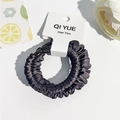 Vue détaillée du chouchou en satin gris plissé présenté sur un emballage blanc - Style B / Violet foncé
