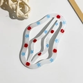 Dettaglio del fermaglio a onde color crema con motivi a mela rossa e stella blu - Stile Nuvola a Onde / 6.5cm / Stampa Stella Pentagramma Blu