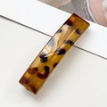 Gros plan d'une grande barrette à imprimé léopard montrant les détails écaille de tortue ambre - Mince Rectangle Écaille Brillante (8.5cm)