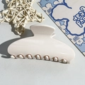 Détail d'une pince à cheveux blanc crème brillante sur un fond décoratif élégant - Tête Carrée 10.5CM / Blanc Cassé