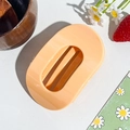 Close-up of glossy orange semi-round hair claw clip with multiple teeth on white background - Oval Clip / Orange