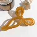 Dettaglio della grande pinza per capelli in resina ambrata con candele decorative - Giallo Senape Trasparente