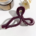 Detailed close-up of a glossy wine red bow hair claw clip with golden metal spring - Solid Purplish Red