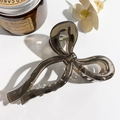 Detail of a brown bow hair claw clip made of acrylic on a white minimalist background - Transparent Light Coffee