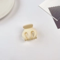 Gros plan d'une petite pince à cheveux crème sur une assiette minimaliste en céramique - 5cm Pince Citrouille-Blanc Crème Mat