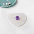 Gros plan d'une mini pince à cheveux fleur violette sur un fond décoratif en feutre blanc - Violet