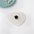 Détail d'une mini pince à cheveux fleur noire sur tapis en feutre blanc avec des perles - Noir